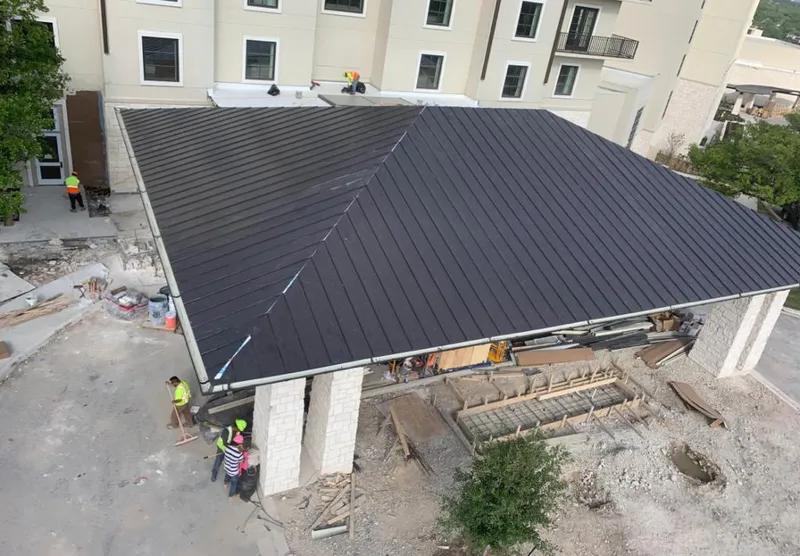 Metal roofing installation team working on a commercial building in Gurnee